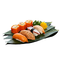 A close-up shot of a Naeki's sushi platter on a green bamboo leaf. The platter includes a variety of nigiri and maki sushi, such as salmon nigiri, seared salmon nigiri, octopus nigiri, and shrimp nigiri. Two pieces of maki rolls topped with orange flying fish roe (tobiko) are also on the platter. A yellow chrysanthemum and a sprig of green garnish are placed at the top right. The background is completely black, making the sushi stand out.