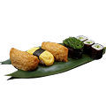 A close-up shot of a Naeki's sushi platter on a green bamboo leaf. The platter includes different types of sushi, arranged from left to right: two pieces of inari sushi, one piece of tamago nigiri (egg sushi), one piece of seaweed nigiri (seaweed salad), and three pieces of kappa maki (cucumber rolls). The background is completely black, making the sushi stand out.