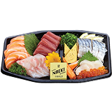 Naeki's sashimi set tray of assorted sashimi on a black platter. The sashimi includes a large serving of sliced salmon on the left, fatty tuna (otoro) in the center, and what appears to be yellowtail or seabream below the tuna. To the right are pieces of saba (mackerel) and two pieces of sweet egg omelet (tamagoyaki). In the front right are scallops with salmon roe. A small yellow pack of soy sauce is in the center with a yellow flower for garnish.
